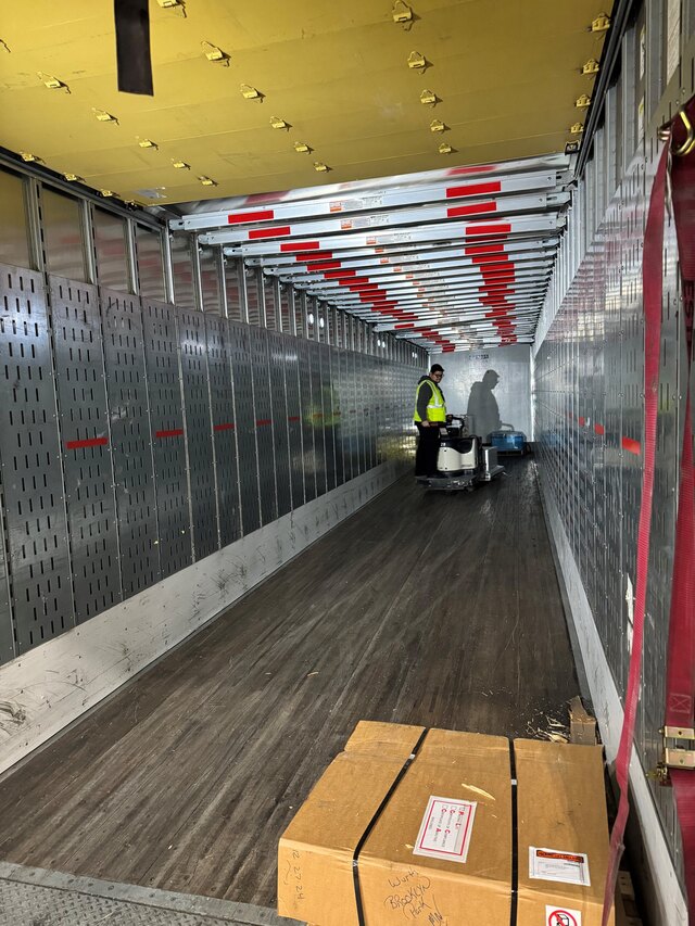 KSP team member loading labeled cartons into a dry van for a store delivery