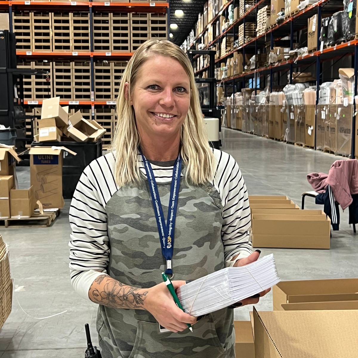 KSP associate on the warehouse floor wearing a lanyard printed with KSP's core values